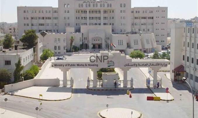 40-920x403 - Center News Network Front view of a government complex with a large curved entrance gate reading 'Ministry of Public Works & Housing' and a circular drop-off area in the foreground.