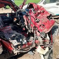 acced - Center News Network Red car severely damaged in a crash with a crushed front end and debris scattered across the scene.