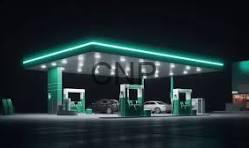Nighttime gas station with green pumps and turquoise neon roof lights, a few cars parked at the islands.
