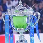 Silver trophy with blue ribbons and a green cup, labeled CNP, on a sports stage.