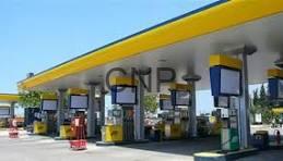 CNPC gas station with several fuel pumps beneath a yellow canopy on a sunny day.