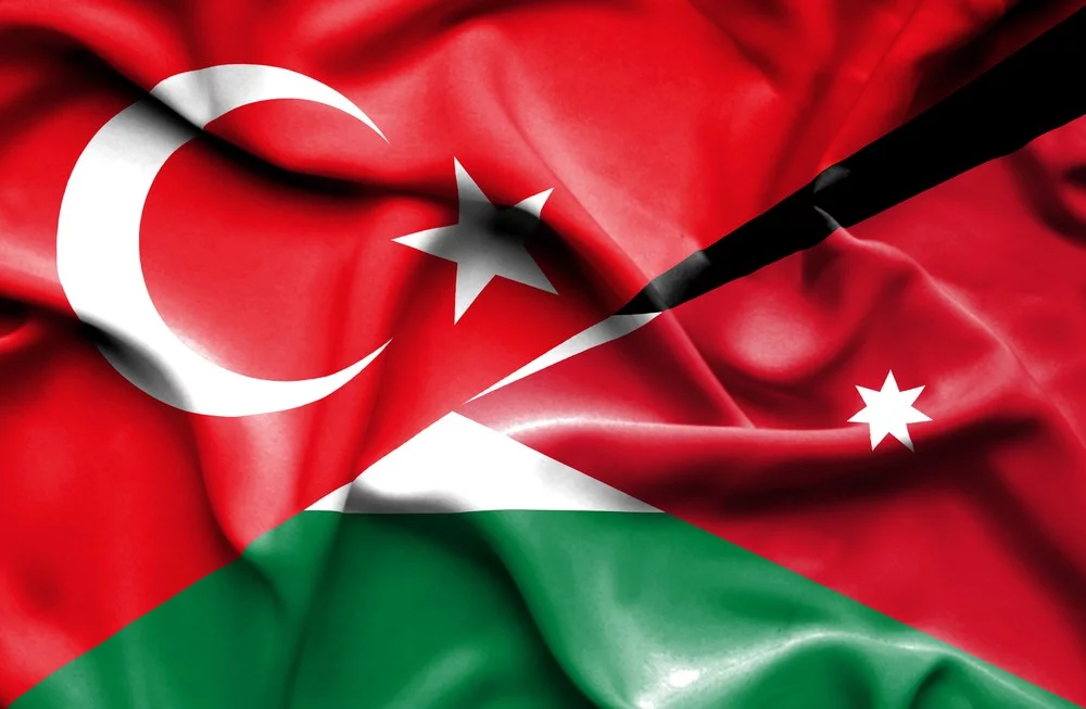 jor - Center News Network A composite flag image blending Turkey's red crescent and star with Jordanian flag elements (red triangle and black/white/green fields), signaling national solidarity or unity.