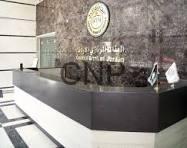 marr - Center News Network Reception desk in a modern lobby with a dark counter, marble floor, and a circular emblem on the wall behind it; the letters 'CNP' are visible on the glass panel.