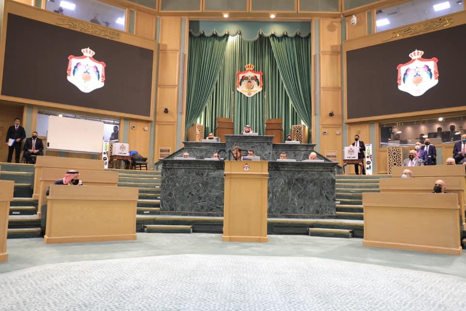 nwa - Center News Network Legislative chamber with a central speaker's podium, green drapes, and crest emblems; officials seated at marble desks on a stepped dais.