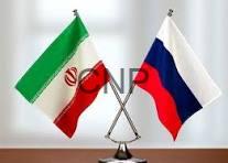 r i - Center News Network Two small national flags, Iran and Russia, crossed on a flag stand on a desk with a blurred office background.