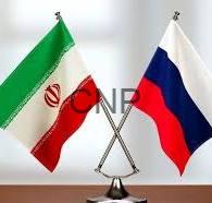 russ - Center News Network Crossed Iranian and Russian flags on a desk stand, symbolizing diplomatic relations.