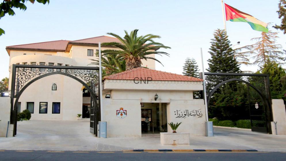 63c7ac2cb6a35 - Center News Network Entrance to a government building with open arches, 'CNP' sign, and Jordan flag waving above on the right side.