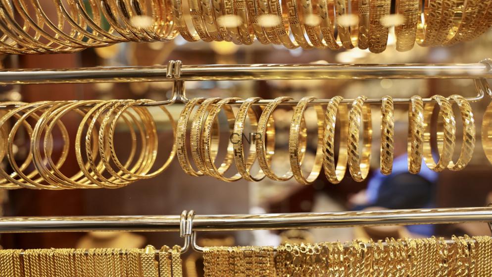 Rows of gold bangles and bracelets on display in a jewelry shop