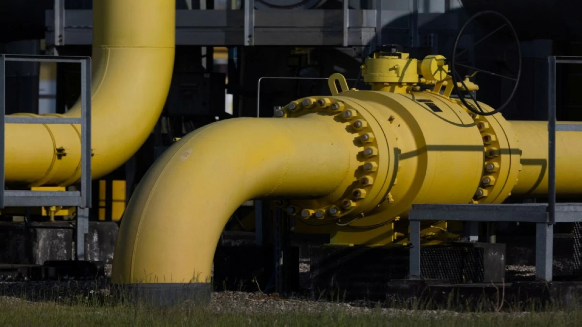 Yellow industrial pipeline with bolted flange connections at a processing facility, close-up view