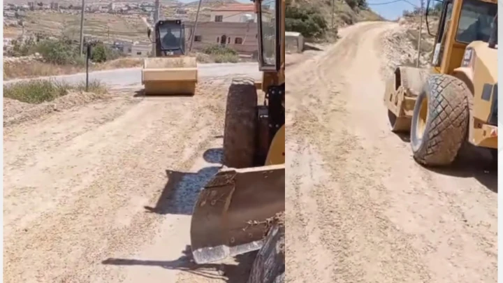 Two construction vehicles on a dusty rural road: a road roller in the foreground and a wheel-loader behind it, leveling the dirt road.