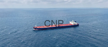 - Center News Network A large cargo ship sailing across a calm blue ocean, viewed from above.