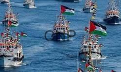 SOMOD - Center News Network Several small boats display tall colorful flags as they float on a bright blue sea in a harbor or open water area.