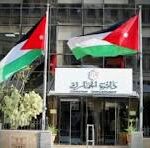 Two flags with red triangles at the hoist fly above the entrance of a building labeled 'CNP'.