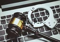 elec - Center News Network Gavel and handcuffs on a laptop keyboard, symbolizing legal action against cybercrime or tech-related crime.