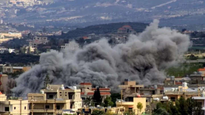 A large dark smoke plume rises over a residential neighborhood, suggesting an explosion or bombing in progress.