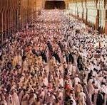 Massive crowd of people filling a long indoor corridor, viewed from above.