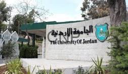 jam - Center News Network Entrance sign for The University of Jordan with its emblem and surrounding plants and gate in the background.