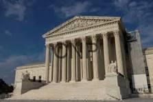 U.S. Supreme Court building with tall white columns and a triangular pediment on a sunny day.