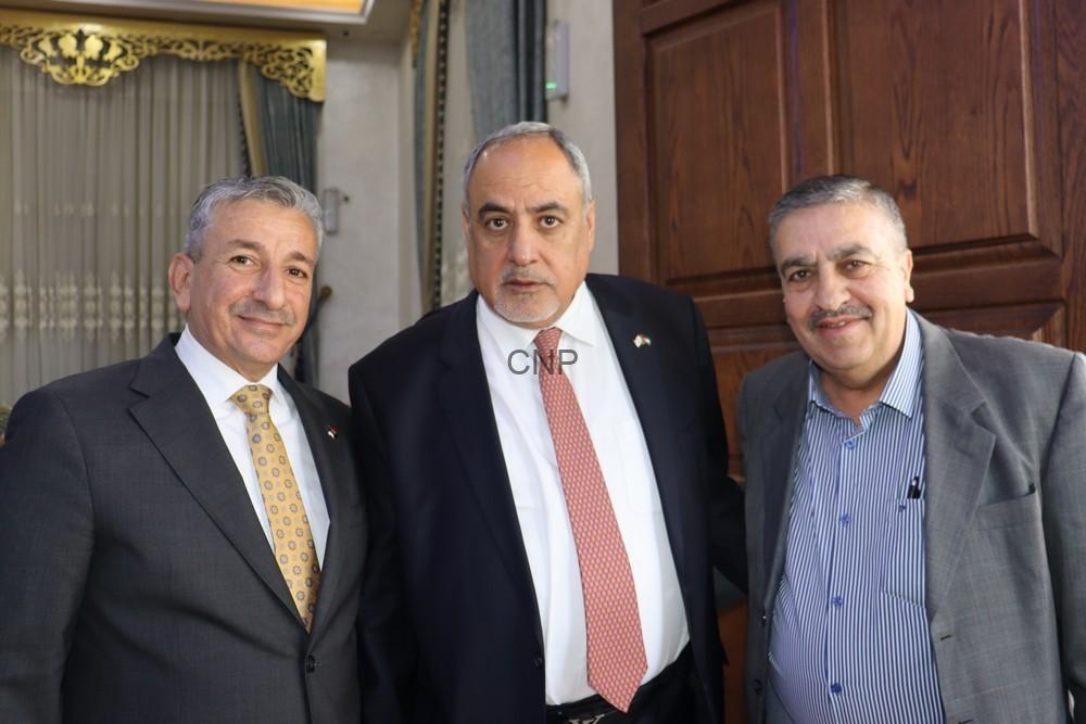 maan3 - Center News Network Three men in suits posing for a photo indoors, standing in a doorway