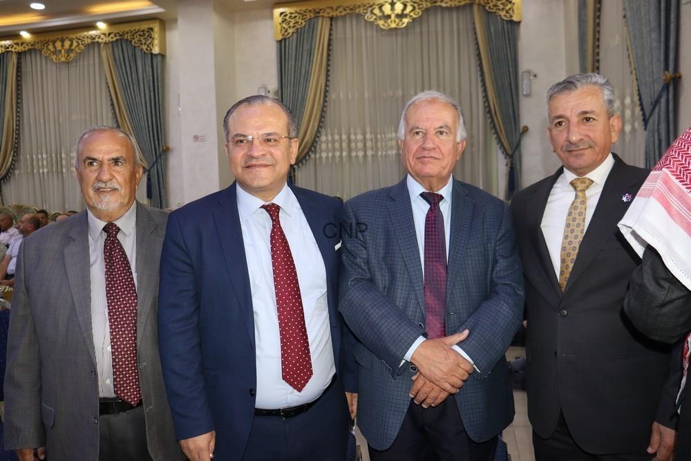 maan4 - Center News Network Four men in suits posing for a formal event in an ornate room with gold decor and blue curtains.