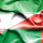 Wrinkled flags of Iran (left) and Oman (right) with 'CNP' text in the center to indicate a cross-country theme.