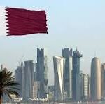 Red flag with a white serrated edge flies over a modern city skyline with palm trees and glass high-rises on a clear day.