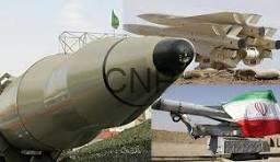 Two missiles on display outdoors: a large gray missile in the foreground and a smaller, flag-marked missile with a red tip in the background.