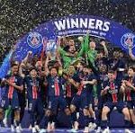 Sports team celebrating a championship on a podium with a blue 'WINNERS' arch and confetti scattered around.