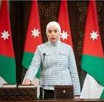 Woman at a podium giving an official briefing, with Jordanian flags behind her.