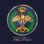 Circular government insignia featuring a crowned eagle, laurel wreath, and crossed tools with Arabic text around the bottom on a dark blue background