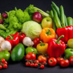 Assortment of fresh vegetables and fruits on a dark background, including peppers, tomatoes, cucumbers, lettuce, onions, cabbage, and broccoli.