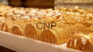 - Center News Network Row of gold bullion coins arranged in a tray, with a CNP watermark visible on some coins.