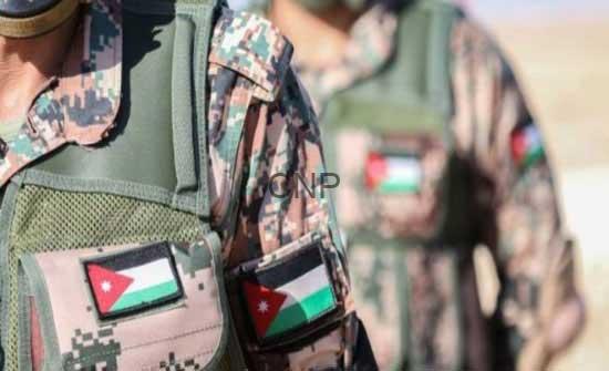 - Center News Network Close-up of two soldiers in camouflage vests with Jordan and Palestinian flag patches, in a desert setting.