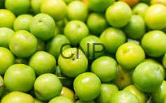 Close-up of fresh green limes piled together in a basket or pile.