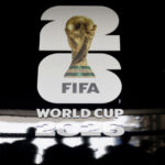 Promotional display for the FIFA World Cup featuring a gold trophy silhouette and bold white numbers with the words 'WORLD CUP' beneath.