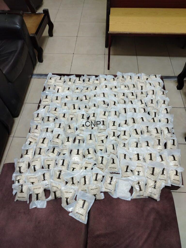 Many small white bags laid out in a grid on a coffee-table-like surface in a living room setting.