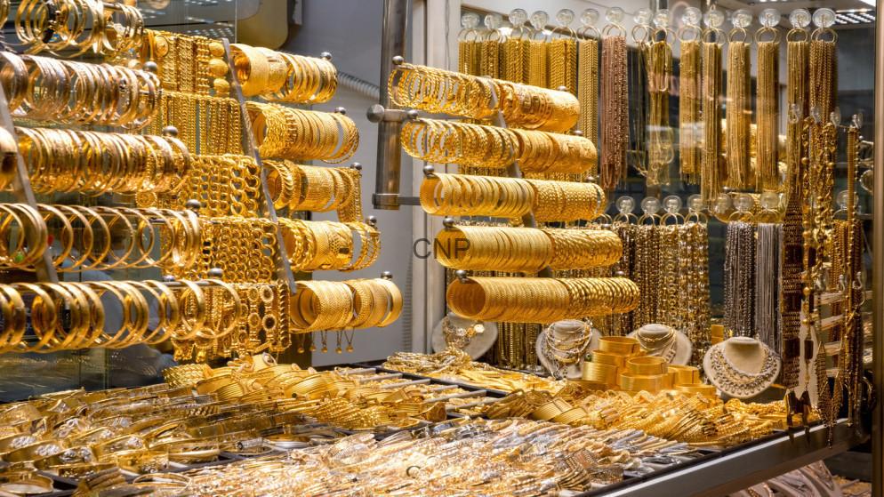 golld - Center News Network Gold jewelry display with stacked bracelets, bangles, and necklaces in a shop window.