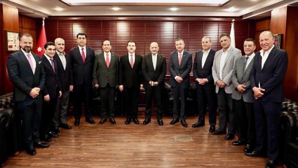 kord - Center News Network Twelve men in suits standing in a formal meeting room with wooden paneling and flags in the background.