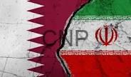 Close-up of the Iranian flag showing red serrated edge, white band with Kufic script, and the emblem in green/red hues.