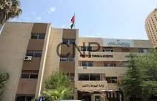 Three-story brick campus building with a flagpole and trees; 'CND' sign on the front.
