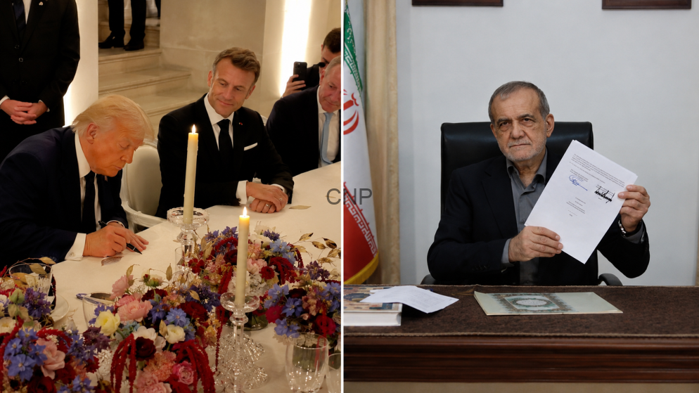 Two men in suits sign a document at a formal signing table with candles and a flower centerpiece on the table.