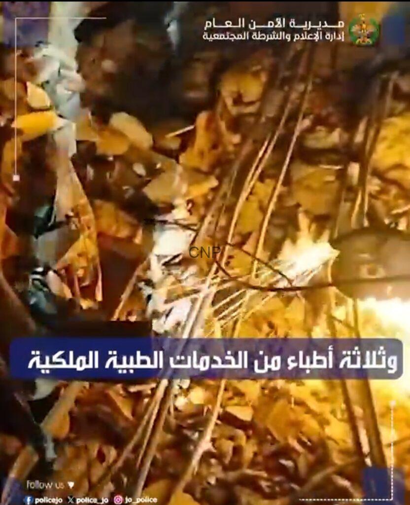 Night-time collapsed building scene with rubble and metal scaffolding; first responders from the Royal Medical Services assisting victims, as shown by the Arabic news banner at the top and bottom.