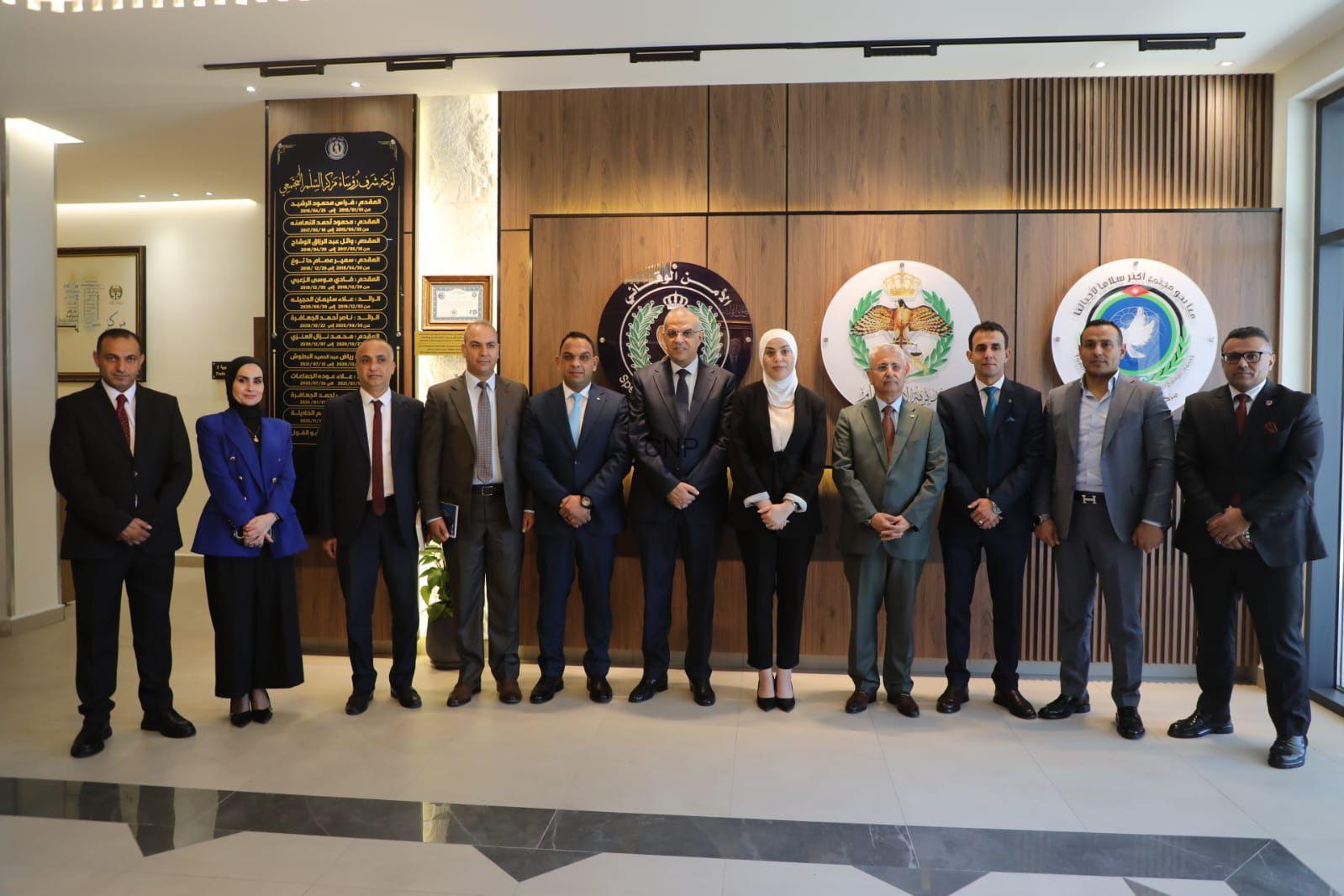 tan - Center News Network Group of ten professionals in formal attire standing in a lobby with wood panels and organizational emblems behind them.