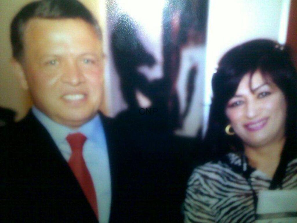 wk - Center News Network Two adults posing for a photo, smiling at the camera, man in a suit with a red tie and woman with striped top on the right.