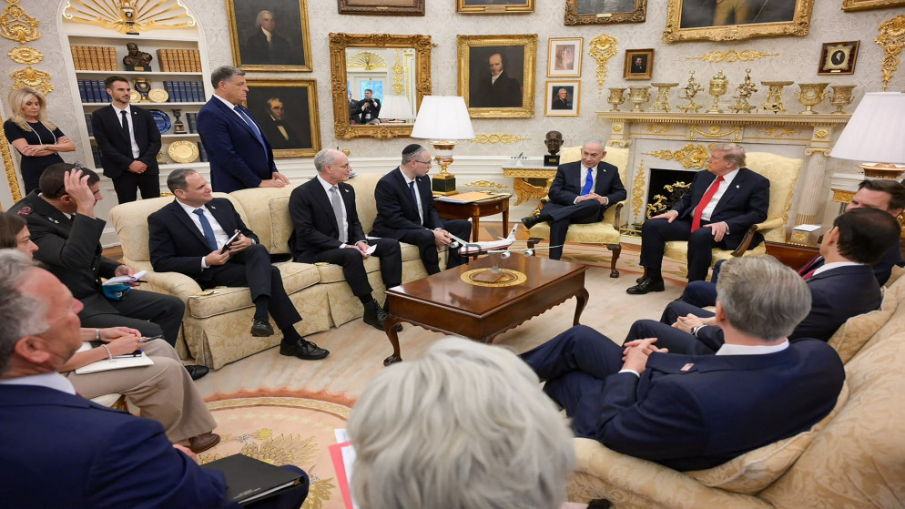 Group of world leaders seated in a gilded, portrait-filled parlor, discussing around a central coffee table.