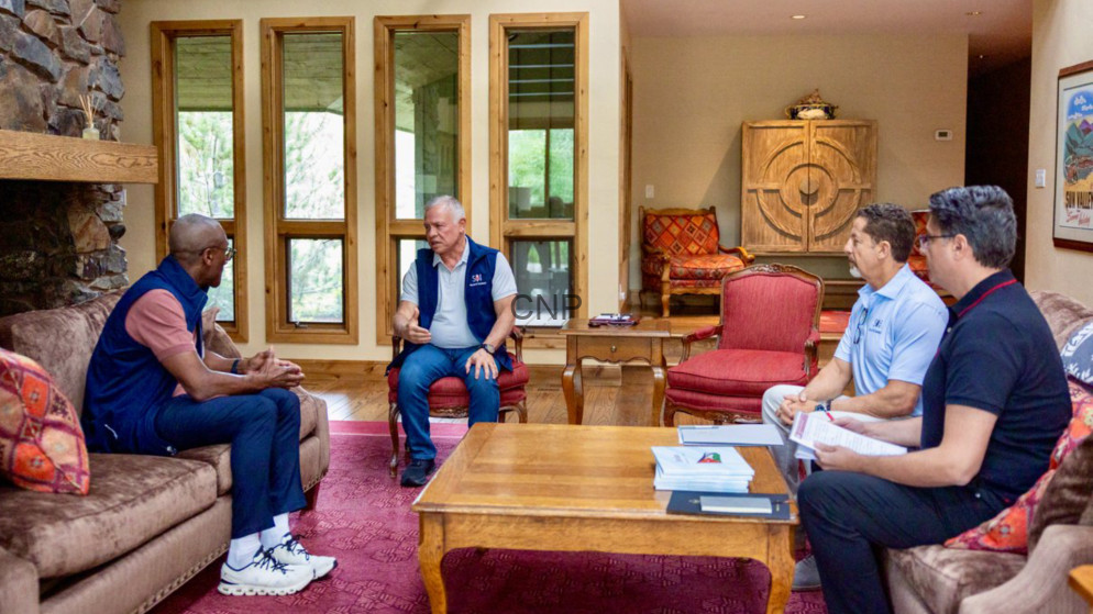image - Center News Network Five men sit in a cozy living room around a wooden coffee table, engaged in a discussion.