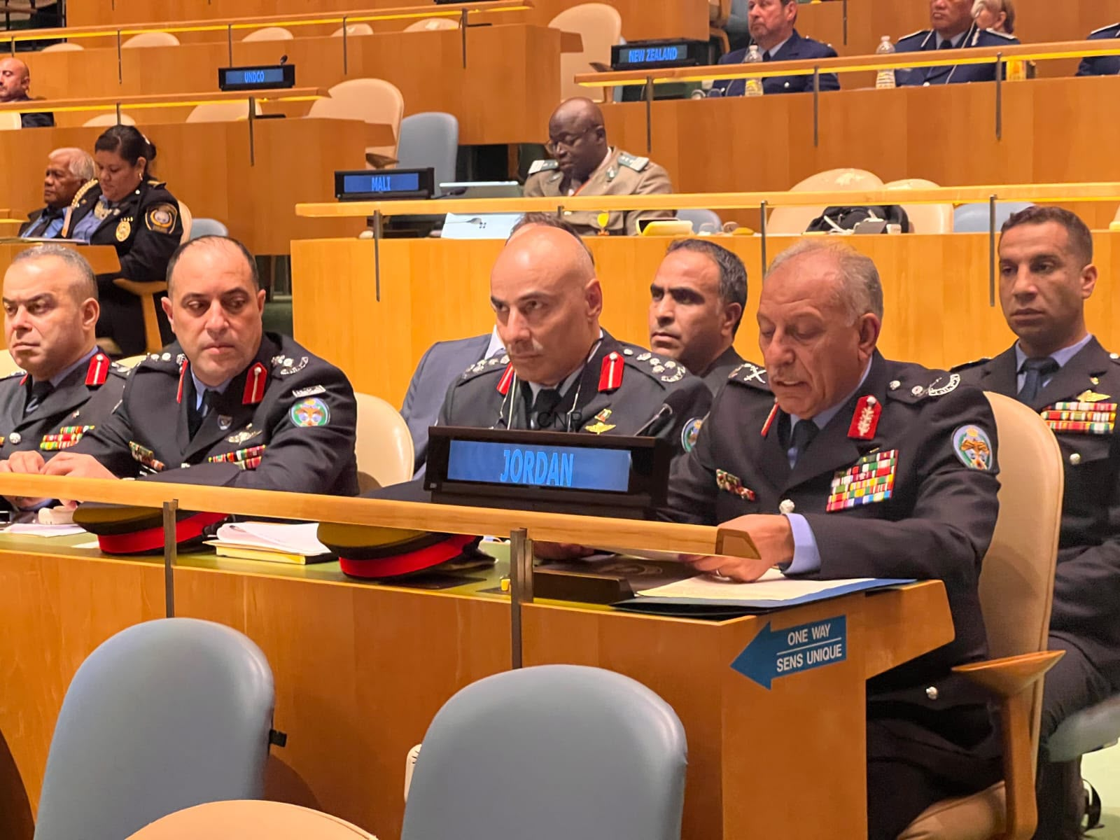image - Center News Network Row of high-ranking military officers in dress uniforms seated at a conference desk, 'JORDAN' nameplate in front of the central officer, badges and ribbons visible.