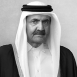 Black-and-white portrait of an older man wearing traditional Arab dress, facing the camera.