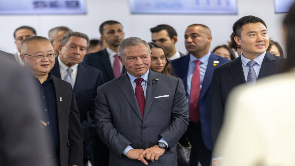 image - Center News Network Group of business professionals in suits at a formal event, with a man in a gray suit and red tie center.