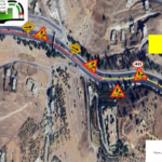 Aerial view of a road under construction with multiple orange warning signs, speed limit 40, and a yellow banner with Arabic text in the top-right corner.